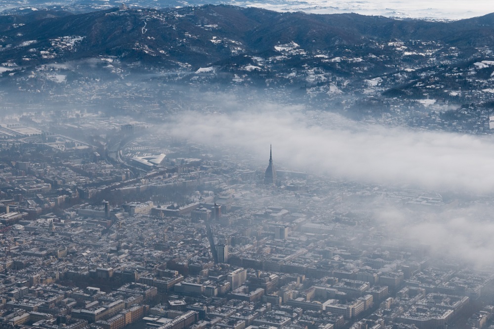 Turin aerial view. Torino cityscape from above, Italy. Winter, fog and clouds on the skylline. Smog and air pollution.